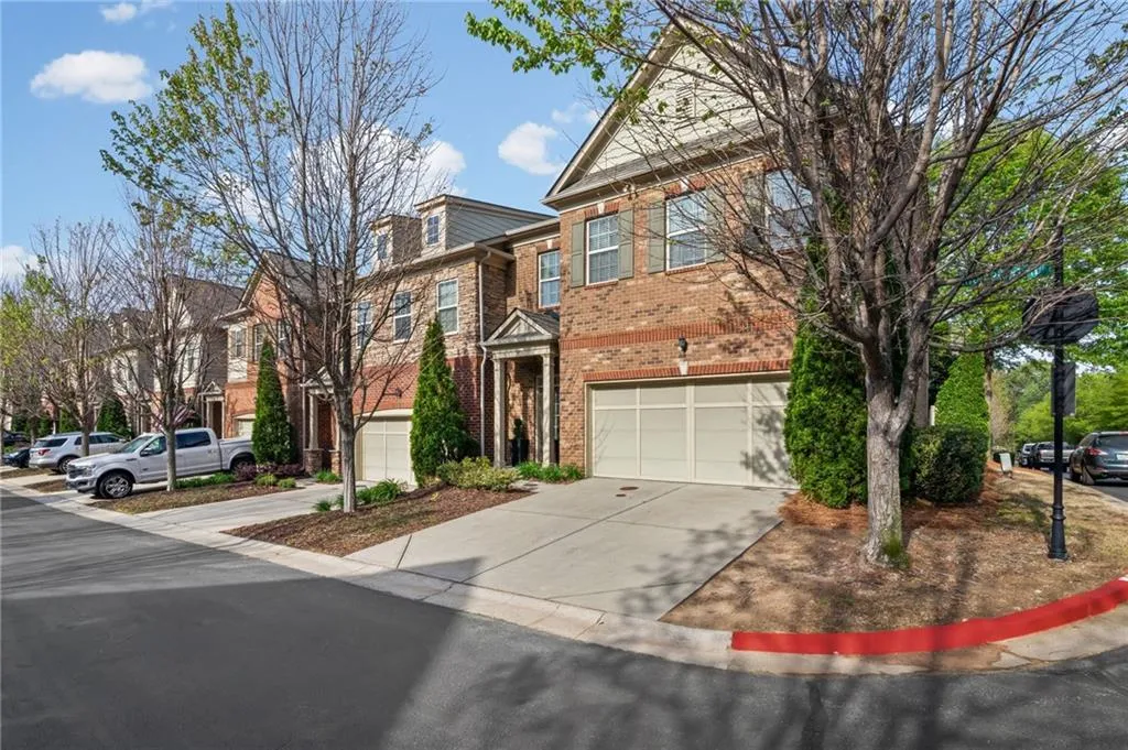 Traditional home featuring driveway, an attached garage, and brick siding