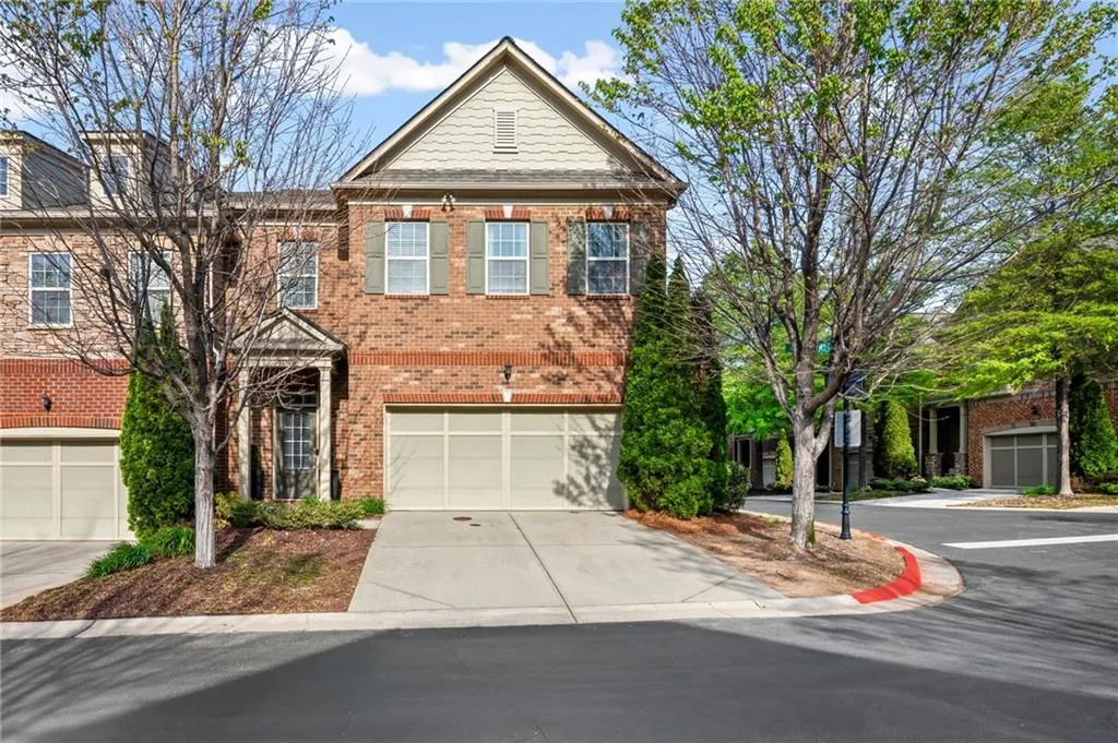 View of front of property with brick siding, concrete driveway, and an attached garage
