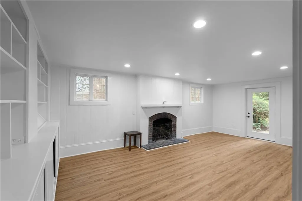 Unfurnished living room featuring recessed lighting, a fireplace, baseboards, and light wood-style floors