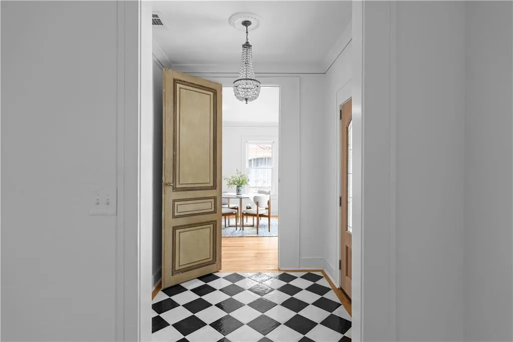Entryway with a chandelier, crown molding, light floors, and baseboards