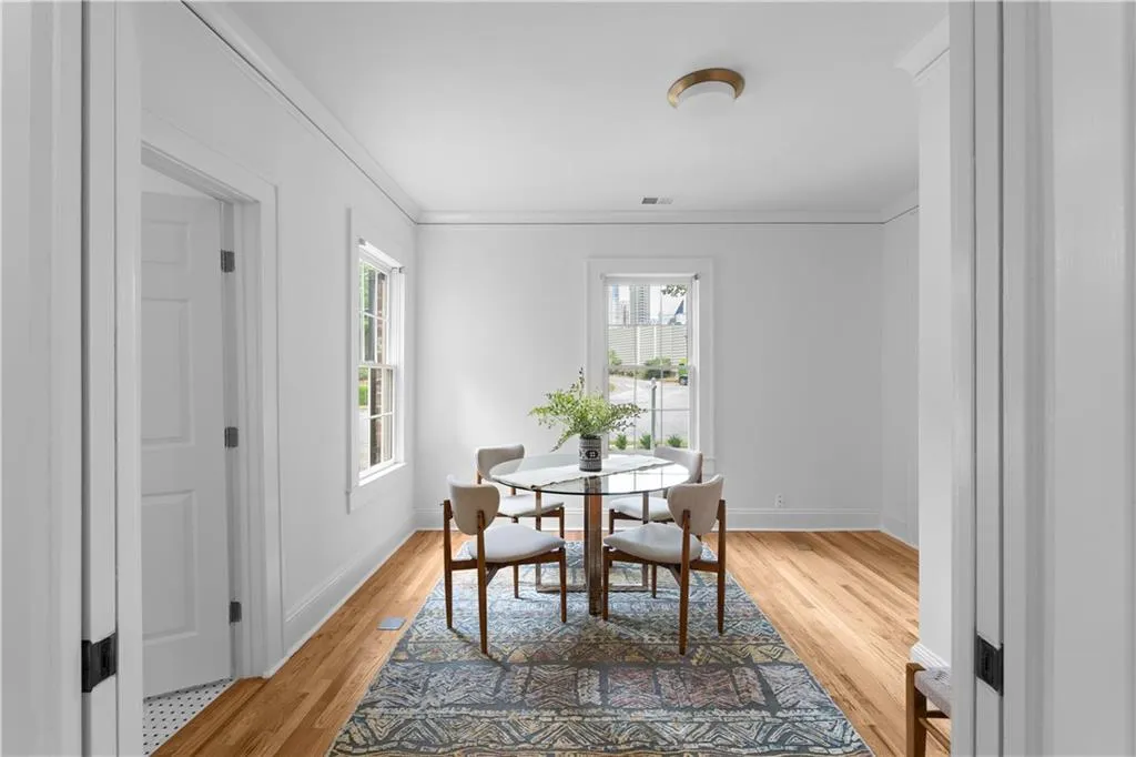 Dining room with plenty of natural light, light wood finished floors, ornamental molding, and baseboards