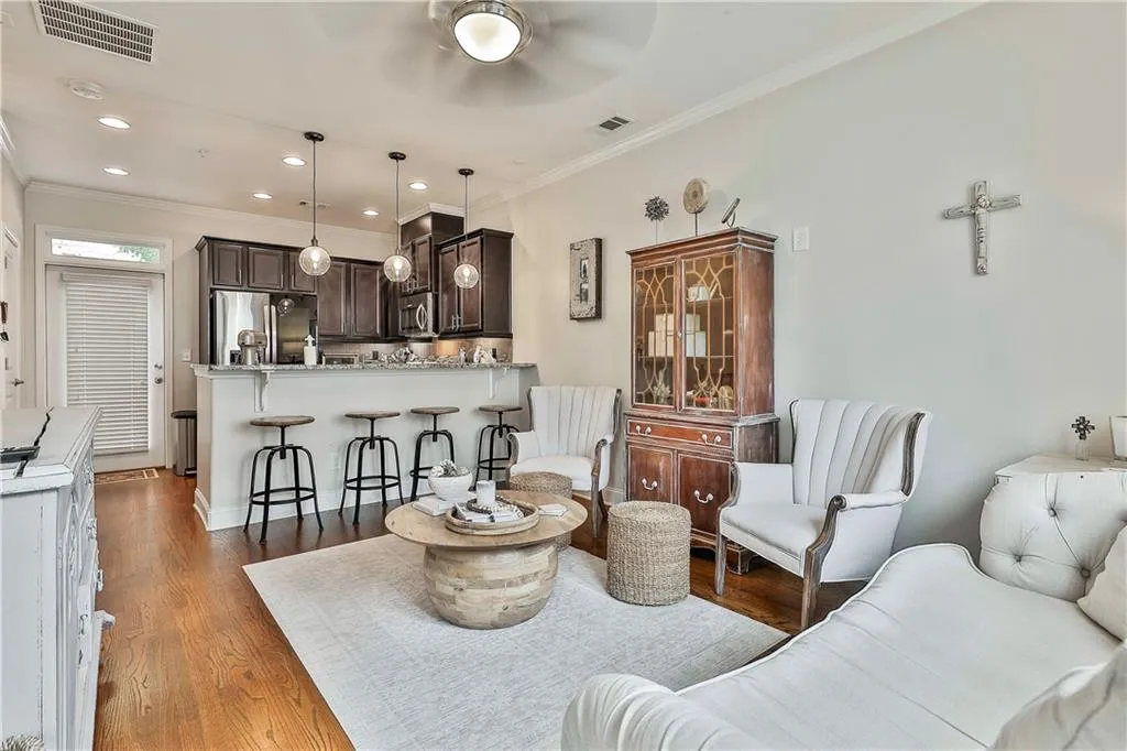 Living room featuring dark wood-type flooring, crown molding, and recessed lighting