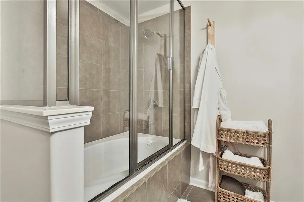 Full bathroom with tiled shower / bath combo and tile patterned floors