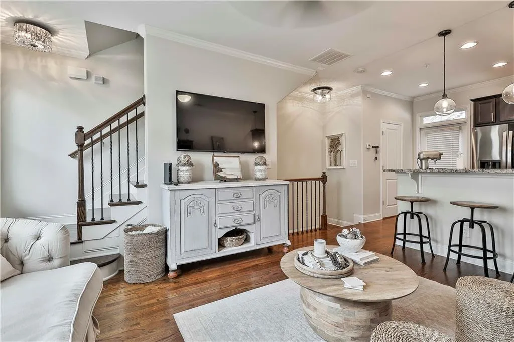 Living area with ornamental molding, dark wood-style flooring, recessed lighting, and stairs