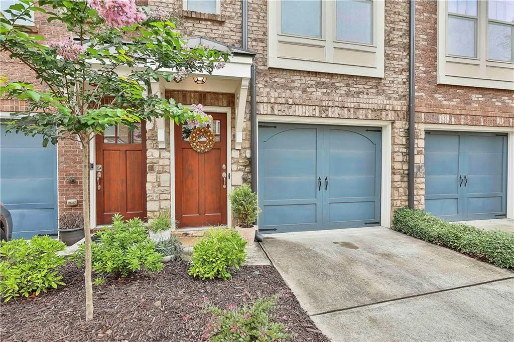 View of exterior entry with stone siding and a garage