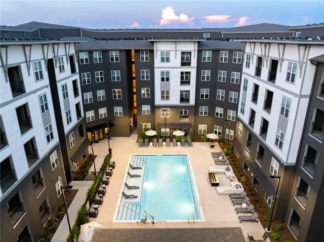 Pool at dusk featuring a community pool and a patio area