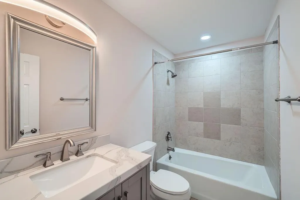 Bathroom featuring shower / tub combination, vanity, and toilet