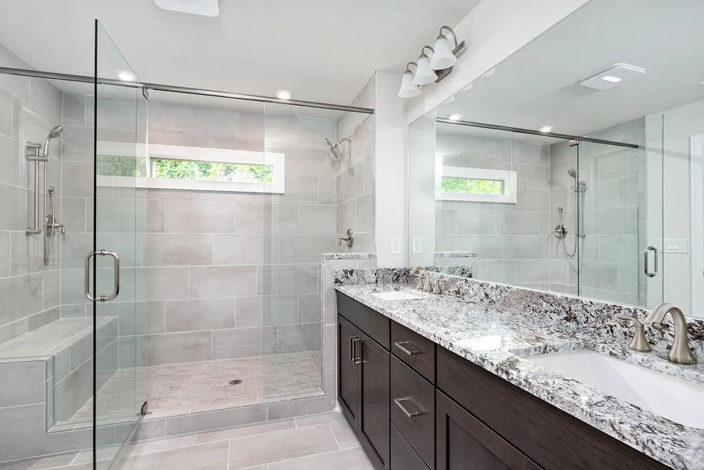 Bathroom featuring healthy amount of natural light, double vanity, a stall shower, recessed lighting, and tile patterned floors