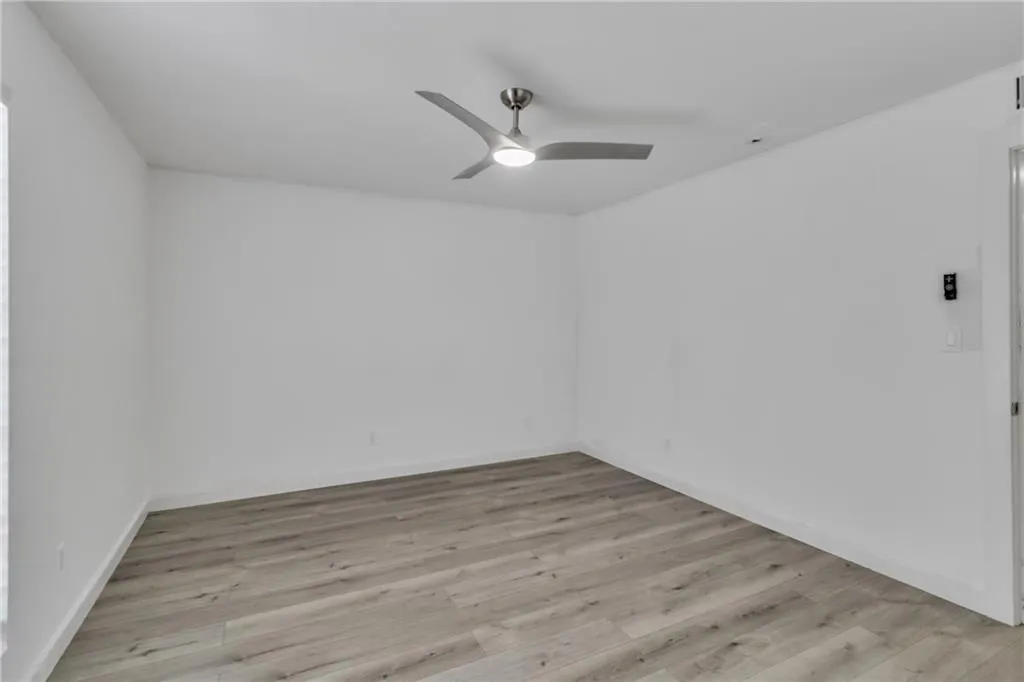 Spare room with light wood finished floors and a ceiling fan