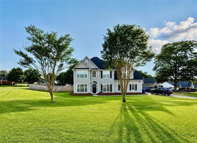 Two-story residence featuring a light gray exterior with black window shutters and white trim