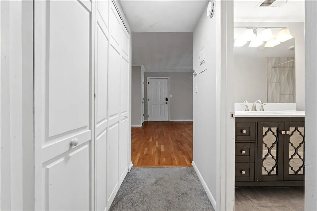 Hallway with light carpet and baseboards