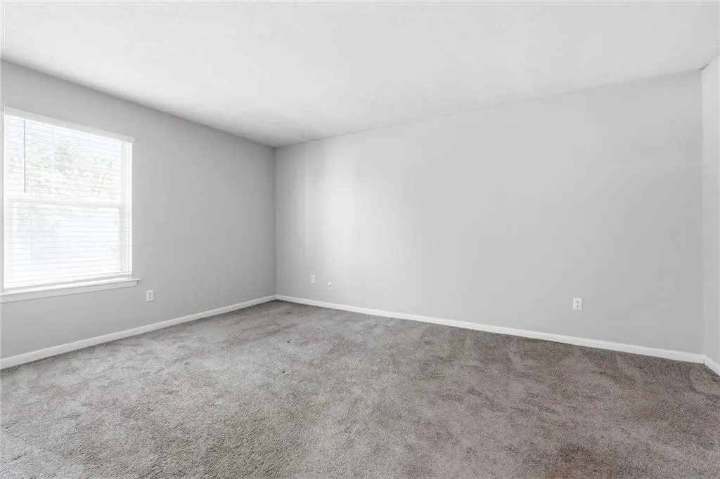 Carpeted empty room featuring baseboards