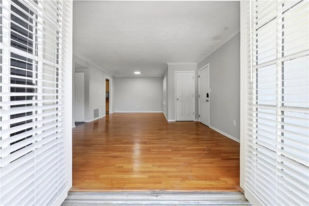 Entryway with ornamental molding and light wood-style floors