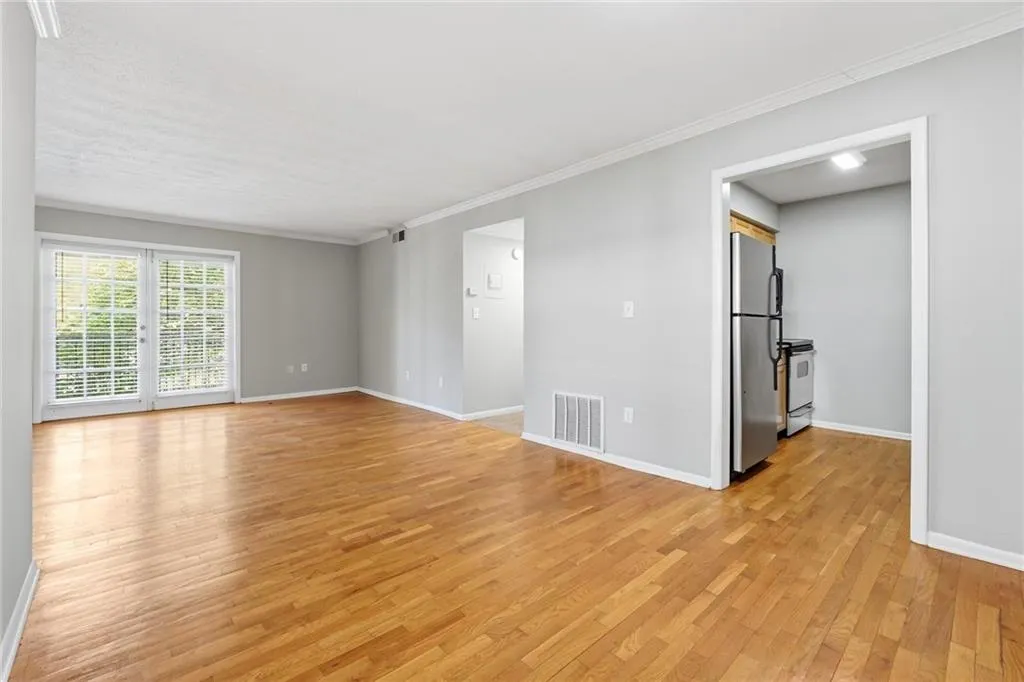Unfurnished room with light wood-style flooring and crown molding