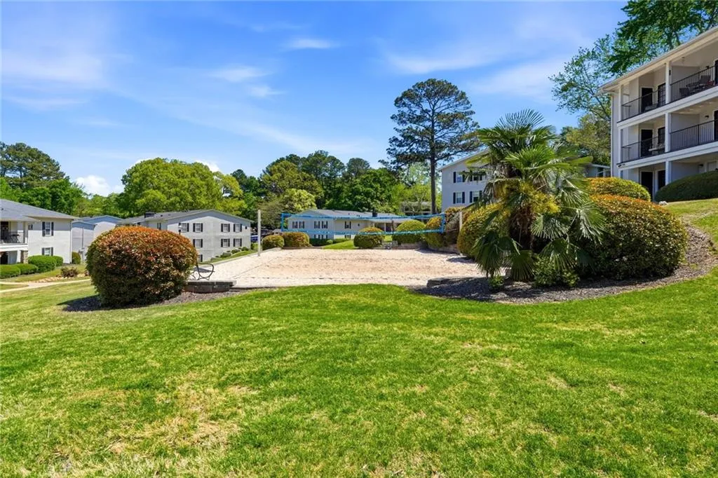 View of grassy yard featuring volleyball court