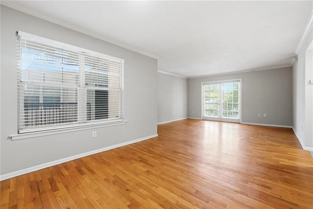 Empty room with light wood-style flooring and crown molding