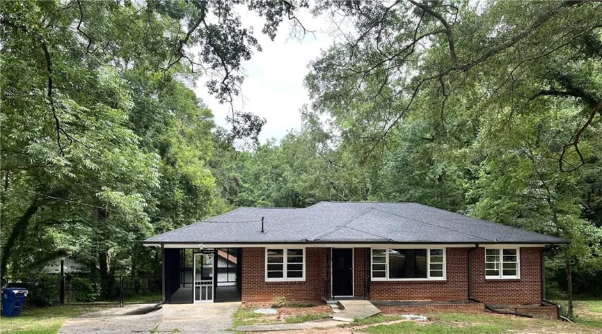 Brick exterior with white window frames, a dark shingle roof, and a screened porch