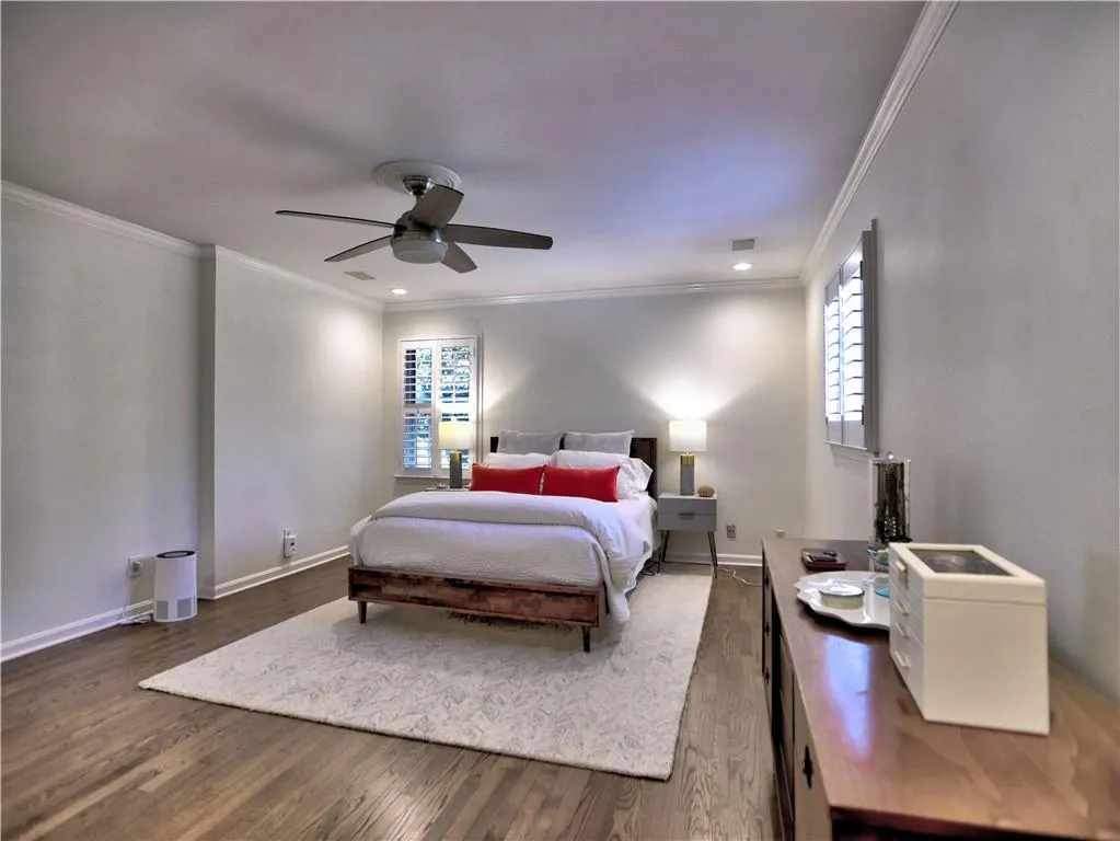 Bedroom with crown molding, dark wood-type flooring, and ceiling fan