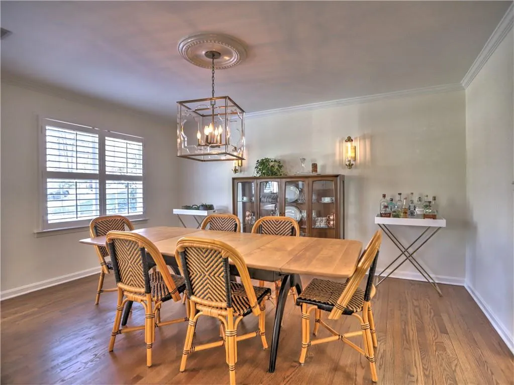 Dining space featuring crown molding, dark hardwood / wood-style flooring, and an inviting chandelier