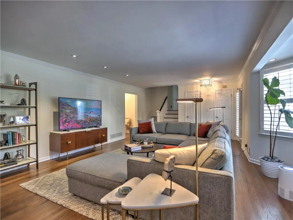 Living room featuring wood-type flooring and ornamental molding