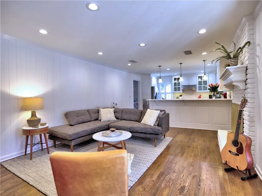 Living room with dark hardwood / wood-style flooring and ornamental molding