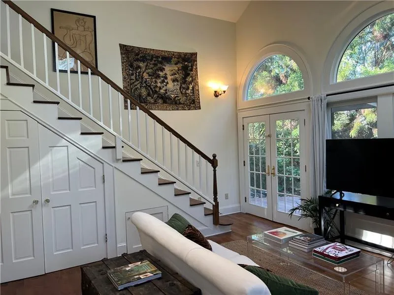 Entryway featuring stairway, french doors, dark wood-style floors, and high vaulted ceiling