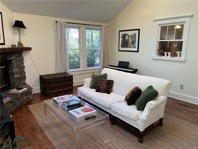 Living area featuring wood finished floors, lofted ceiling, and a fireplace