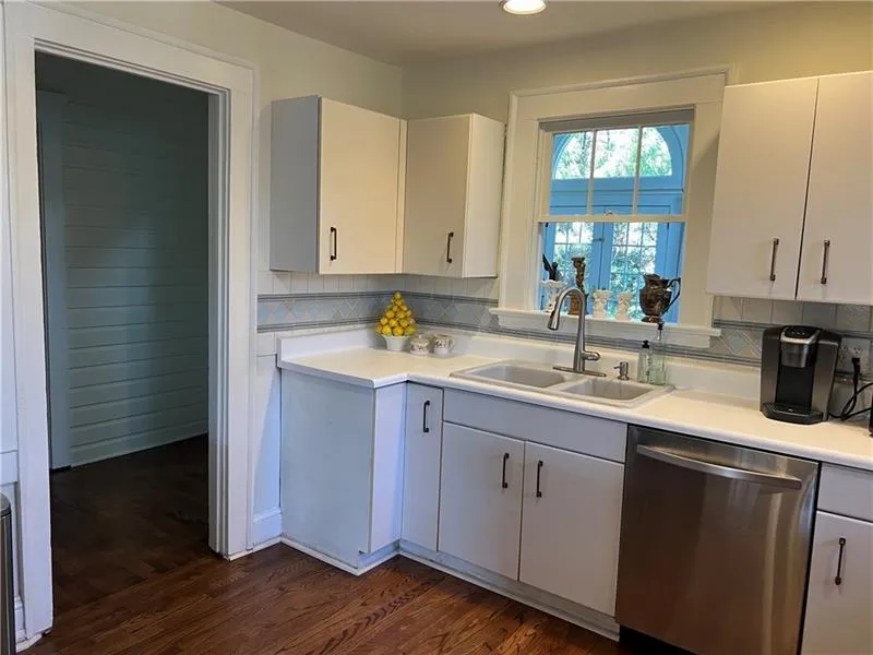 Kitchen featuring stainless steel dishwasher, tasteful backsplash, dark wood finished floors, light countertops, and recessed lighting