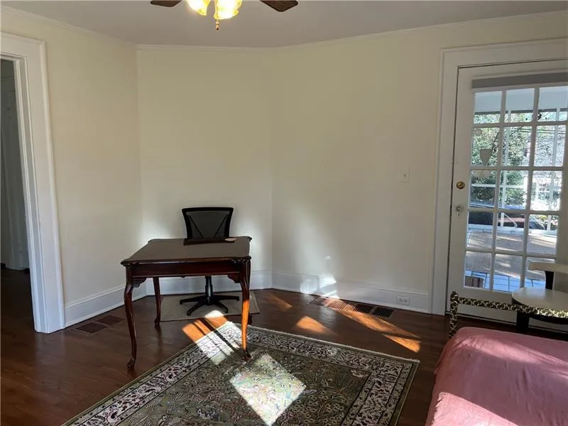Home office featuring wood finished floors, ornamental molding, and a ceiling fan