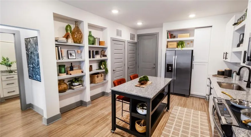 Kitchen featuring open shelves, light stone counters, stainless steel appliances, white cabinetry, and recessed lighting