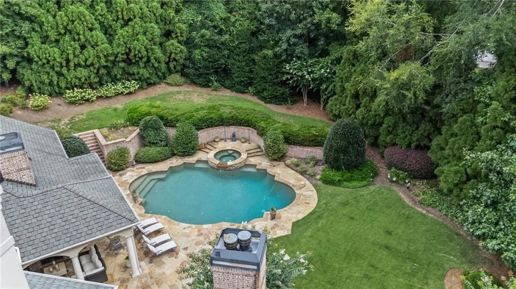 Freeform swimming pool with integrated spa and stone surround