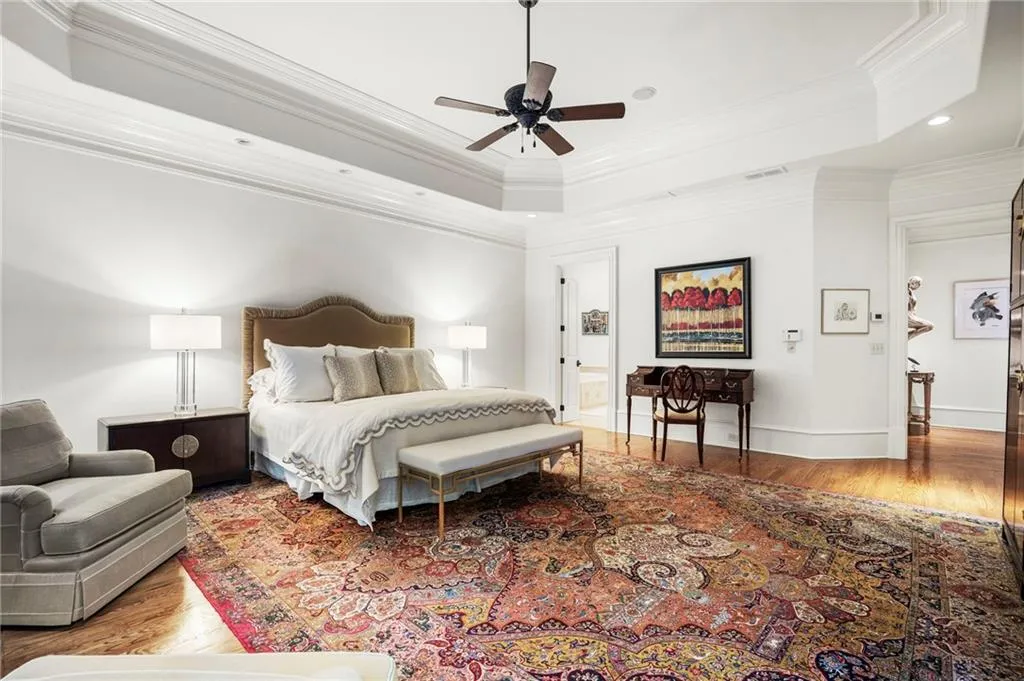 Tray ceiling with crown molding, ceiling fan, hard surface flooring, and recessed lighting