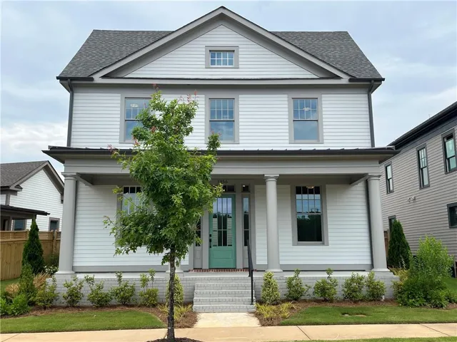 Two-story residence featuring a covered front porch with round columns