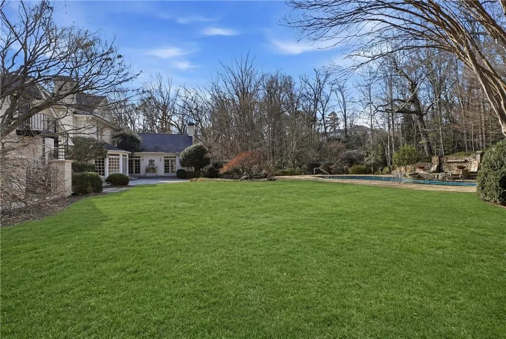View of grassy yard with an outdoor pool, a patio, and french doors