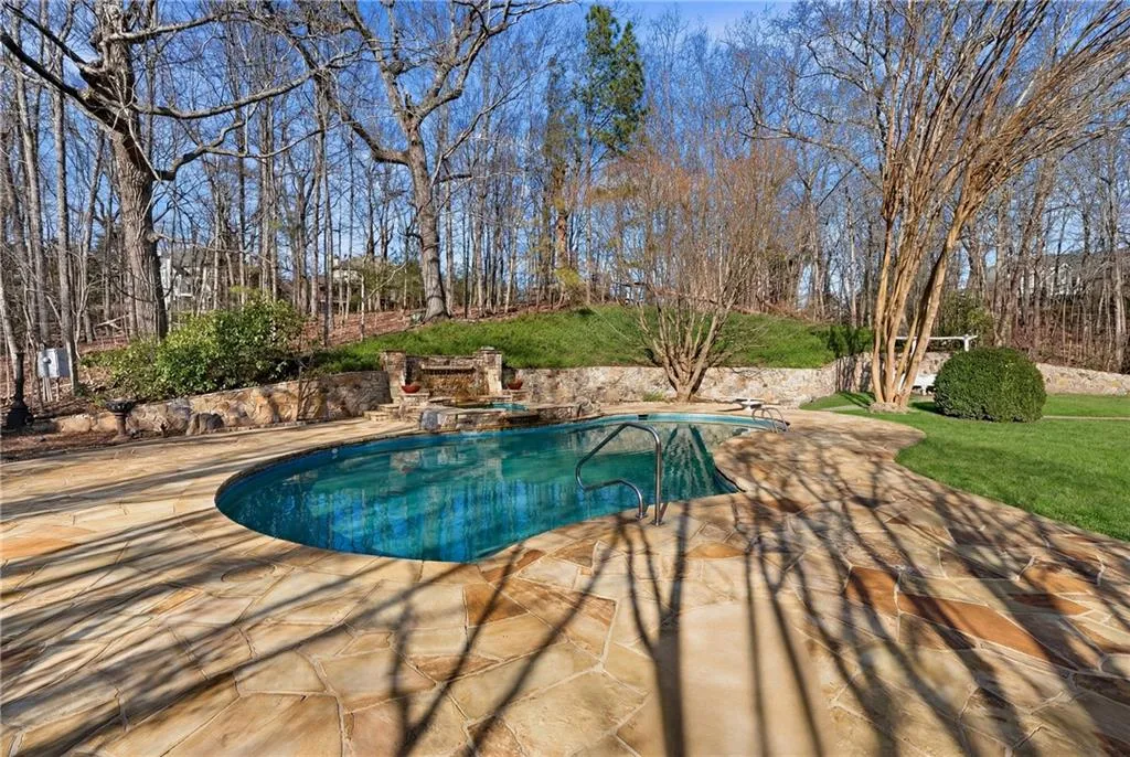 Outdoor pool with a patio area, a yard, and a diving board