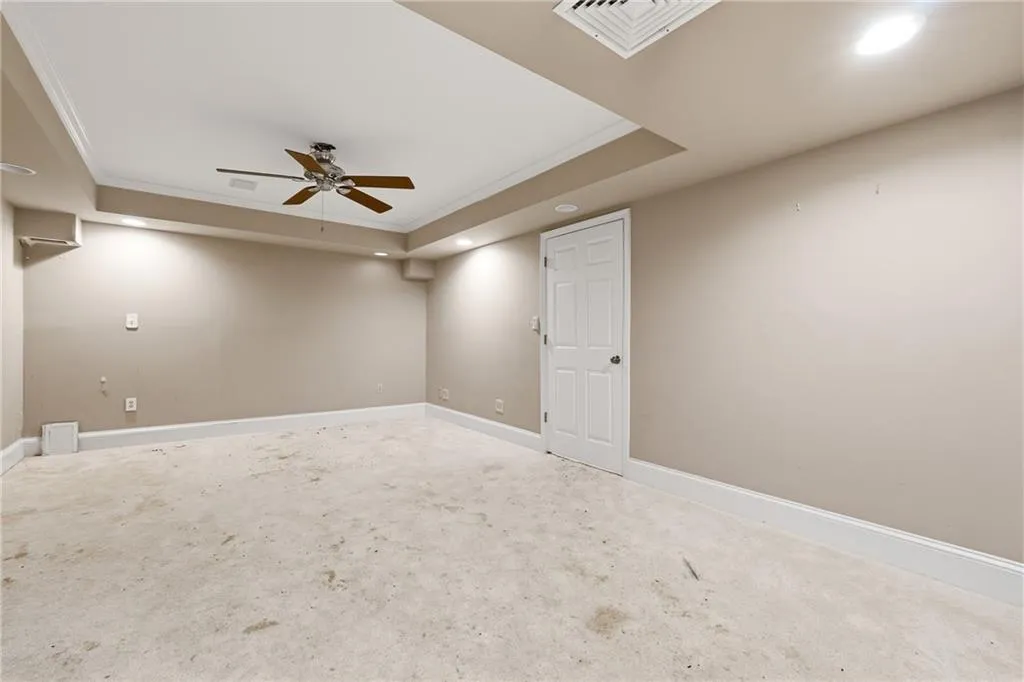Unfurnished room featuring crown molding, a raised ceiling, recessed lighting, a ceiling fan, and carpet