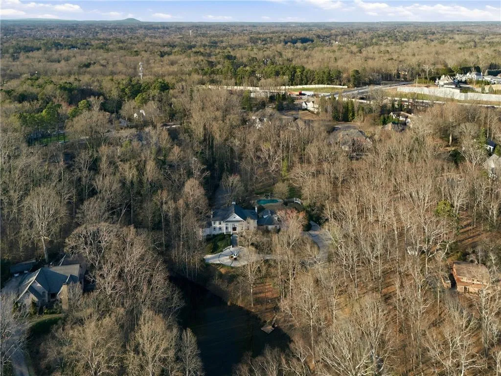 View of property location with a forest and a nearby body of water
