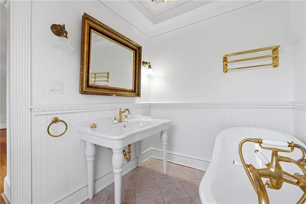 Bathroom with wainscoting, a freestanding tub, and ornamental molding