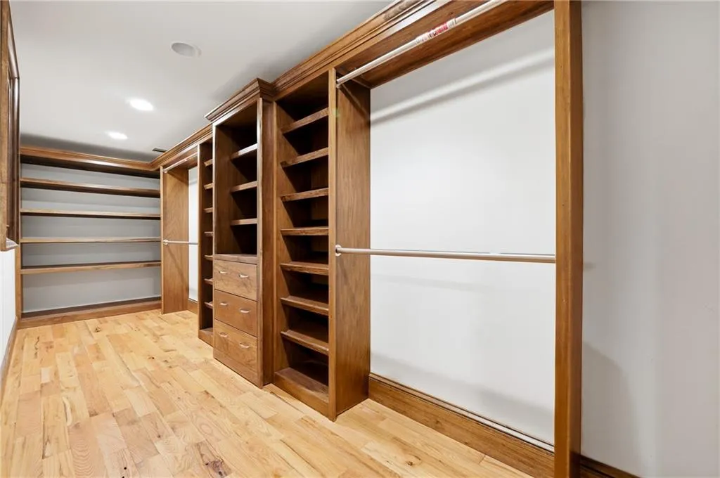 Walk in closet with light wood-type flooring