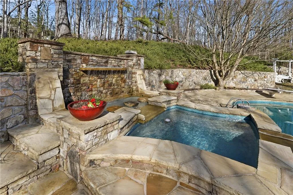Outdoor pool featuring a patio area and an in-ground hot tub