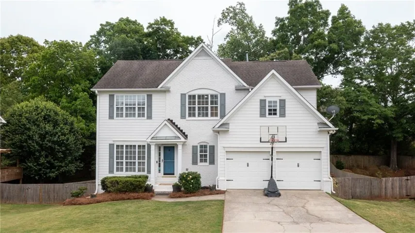 White two-story residence featuring a brick and siding facade