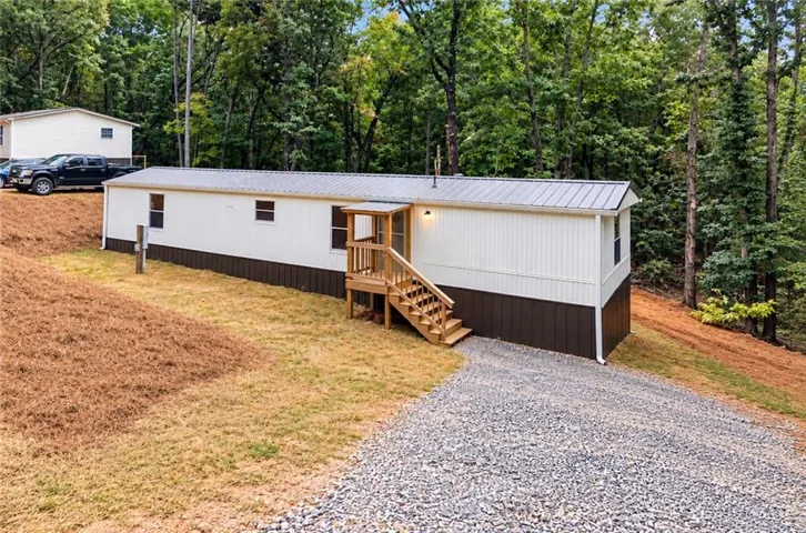 White siding exterior with a metal roof