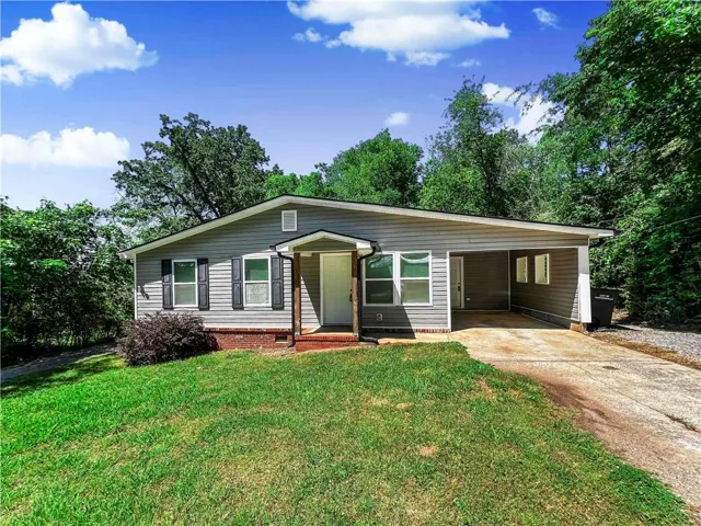 Gray siding exterior with white window trim and black louvered shutters