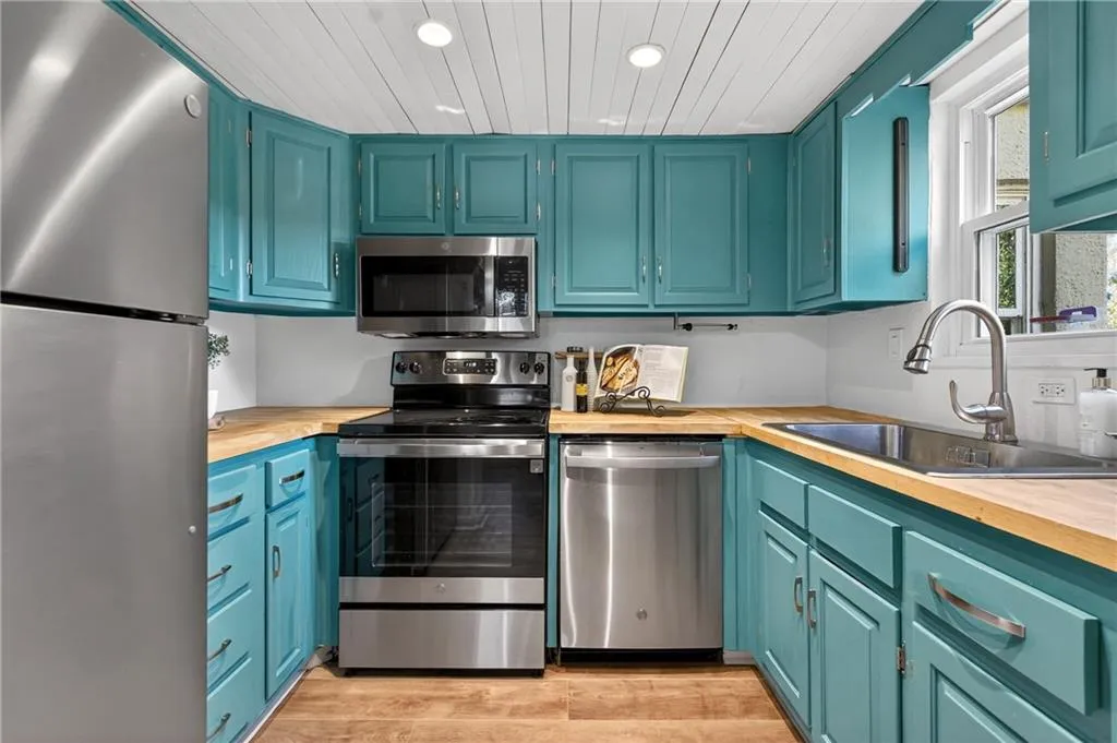 Stylish kitchen with bold designer cabinetry, warm counterops and stainless steel appliances