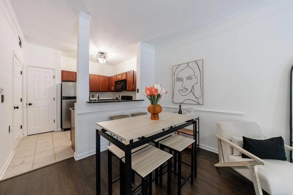 Kitchen with crown molding, kitchen peninsula, stainless steel refrigerator, and light hardwood / wood-style floors