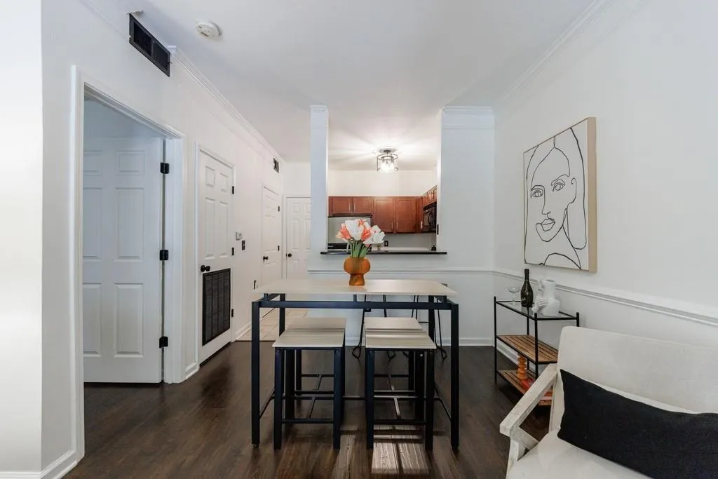 Dining space with ornamental molding and dark hardwood / wood-style floors