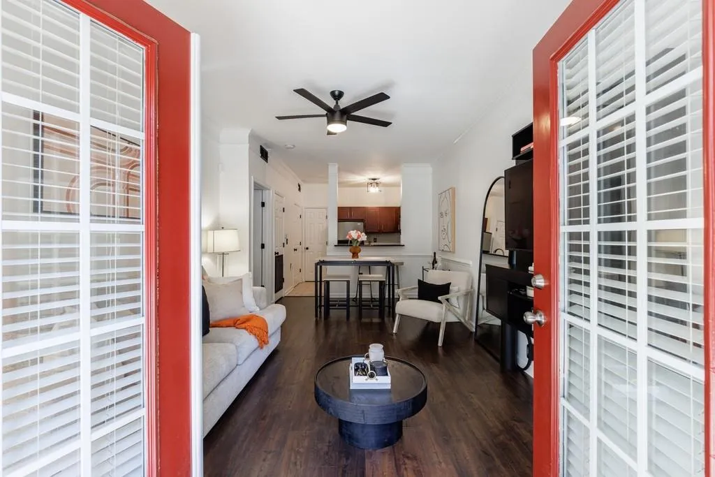 Living room with crown molding, ceiling fan, and dark hardwood / wood-style flooring
