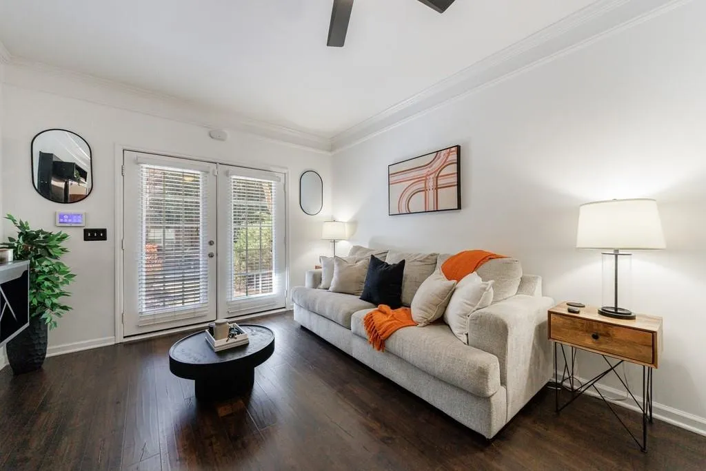 Living room with crown molding, ceiling fan, dark hardwood / wood-style flooring, and french doors