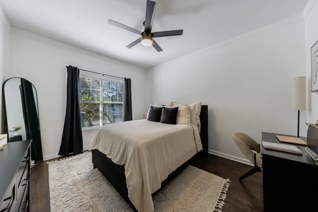 Bedroom featuring ceiling fan, ornamental molding, and dark hardwood / wood-style floors