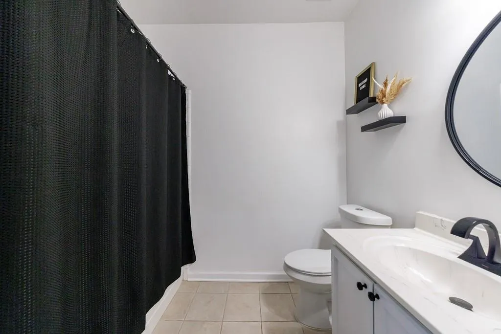 Bathroom featuring tile patterned floors, toilet, and vanity